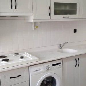 Aquacool 104 Antik Beyaz boyası ile yenilenmiş mutfak dolapları ve tezgah alanı fotoğrafı